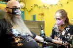 Chuck Miller gets a tattoo touched up by Shawna Holder at her shop Angel Ink Tattoo on Main Street in Oregon City, Ore., on March 1, 2022. Both looked forward to the end of Oregon's indoor mask mandate on March 12.