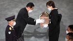 Japan's Prime Minister Fumio Kishida hands the urn of the ashes of former Japanese prime minister Shinzo Abe to his widow, Akie Abe, during his state funeral.