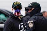People wearing hats and patches indicating they are part of Oath Keepers attend a rally at Freedom Plaza Tuesday, Jan. 5, 2021, in Washington, in support of President Donald Trump.