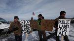 Environmentalists hold signs supporting federal land management at the Malheur National Wildlife Refuge.