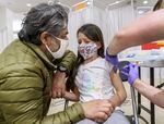 Sumeet Singh, left, comforts his daughter Mila Frey-Singh, 6, of Clackamas, as she receives her vaccination at a pediatric COVID-19 vaccine clinic held at Clackamas Town Center, Nov. 10, 2021, in Happy Valley, Ore. The clinic was offered by the Clackamas County’s Department of Public Health and offered Pfizer-BioNTech vaccines for children ages 5 through 11 years old.