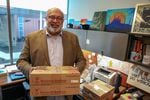 Omer Mozaffar, a Muslim chaplain at Loyola University Chicago, holds boxes of dates in his office.  Dates are usually eaten to break the fast during Ramadan.
