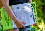 Audrey Caines, campaign manager for the effort to recall Portland Mayor Ted Wheeler, holds posters and literature as she speaks to a group of volunteers learning to gather petition signatures, July 8, 2021 in Portland. 