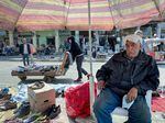Razak Abdul-Zahra Mubarak, 70, is a street vendor in Al Maidan square in Baghdad. Mubarak sits under a faded beach umbrella in front of secondhand shoes he's trying to sell. "Each year it's getting hotter and hotter," he says. "There is no rain. And even the winter has become very short." He says he used to only bring out his beach umbrella in the summer but now uses it all year long.