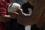 Walking wounded residents wait as rescue teams and civil protection members search the rubble for bodies of victims that perished in the devastating earthquake in Imi N'Tala, Morocco, on Sept. 13.