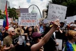 St. Louis: Robert Hull, a 76-year-old demonstrator from St. Charles, left in green, protests alongside his granddaughter Maddie Flynn, 29 of Wentzville, center, during the No Kings protest, in downtown St. Louis. “I cannot stand to see injustices perpetrated against groups of people,” she said. “I have the privilege to speak up and my grandpa taught me to stand up for people who can’t stand up for themselves.”