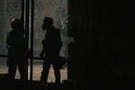 Federal officers emerge from the Mark O. Hatfield federal courthouse in Portland, Ore., to deploy tear gas against people protesting police brutality and systemic racism July 22, 2020. The officers' tactics in Portland have been the subject of national scrutiny.