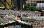 Little orange flags poke up from the playground ground marking sites of potential contamination.