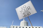 FILE - An attendee holds up a sign during a rally calling for an end to the Senate Republican walkout at the Oregon State Capitol in Salem, Ore., on May 11, 2023.