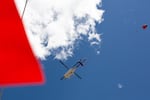 A helicopter battling the blaze in La Pine flies overhead with a helibucket in tow in La Pine, Ore., on June 26, 2024.