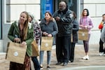 Federal workers stand in line to pickup meals from the World Central Kitchen, Wednesday, Nov. 12, 2025, in Washington.