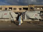 Girls walk past tents in Gaza City on Friday. For two years of war, Gaza's streets shook with the sound of deadly Israeli airstrikes