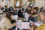 Opponents of a proposed camping ban sit outside of Portland City Hall, many of them watching the live stream of the hearing taking place inside, May 31, 2023. 