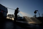 James Lyons, an engineer with the Apple Valley Fire District, sprays hot spots at a home burned by the Palisades Fire, Monday, Jan. 13, 2025, in Pacific Palisades, Calif.