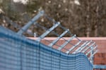 Barbed wire tops a chain link fence