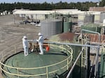 Two EPA employees confer while standing on J.H. Baxter's tank farm in Eugene.