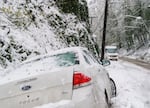 An abandoned vehicle sits in a ditch in this April 11, 2022, file photo from West Burnside Road in Portland. Drivers should be prepared this week for dangerous road conditions as forecasters say the weather is expected to be extremely cold on Thursday and Friday with a likelihood of snow or freezing rain.