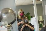 Hair stylist Ceanna Jennifer Lee works with a client on the first day of her salon's reopening on June 6, 2020, Beaverton, Oregon.