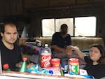 Austin Hall, left, his fiance Victoria Swan and a man who identified himself as Mark Goddard sit in one of the RVs parked on Deschutes Parkway on Washington's Capitol campus.