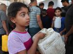 A Palestinian girl holds a container as she waits to collect portable water, in Khan Yunis, in the southern Gaza Strip on Oct. 26, 2023, amid the ongoing battles between Israel and the Palestinian group Hamas.