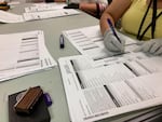 FILE - Workers check ballots at elections offices in Clackamas County, Oregon, Tuesday, May 17, 2022.