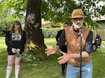 Tim Lewis (right) talks to local media about why he shared EPD bodycam footage from officer Martin Siller in Eugene's Scobert Park. He was joined by Blair Hickok (behind Lewis) and Jetty Etty (left) on May 15, 2026.