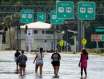 People walk through flood waters last month in Crystal River, Fla. Hurricane Idalia made landfall along the Big Bend region of Florida.