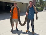 Stephen Gauta (left) and Jake Waleri brought the 19-foot python to the Conservancy of Southwest Florida in Naples, Fla., to have it measured and donated for studies.