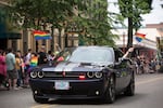 Members of the Portland Police Bureau wave rainbow flags at the crowd during the Portland Pride Parade.