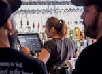 Jordan Lewis takes an order at J-Dub Bar in Bend on June 8, 2022. Bars in the city are expecting an enormous amount of tourists to visit, but many still don't have enough employees to meet demand.