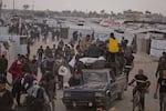 Palestinians carry bags filled with food and humanitarian aid provided by the Gaza Humanitarian Foundation, a U.S.-backed organization approved by Israel, in Khan Younis, southern Gaza Strip, on Tuesday, June 3.