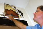 Corbett School District superintendent Randy Trani inspects one of the crumbling walls at the Middle School.