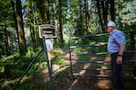 Dennis Deardorff closes the gate for Christilla Pioneer Cemetery in Happy Valley, Ore. on Aug. 27, 2025. The cemetery contains the remains of some of Happy Valley's earliest settlers.