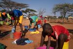 Loshaki (center) washes his clothes in a basin borrowed from one of the other students. Like Paris, he could not afford to buy his own.