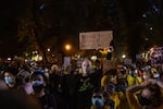 A man holds a sign with the names of Breonna Taylor, George Floyd and Ahmaud Arbery in Portland, Ore., July 25, 2020. Discord has grown in recent weeks as people wonder if the demonstrations have lost their focus on Black lives.