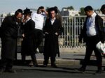 People visit the scene after a shooting attack near a bus stop on Thursday in Jerusalem. The shooting left three dead and 16 wounded, according to authorities.