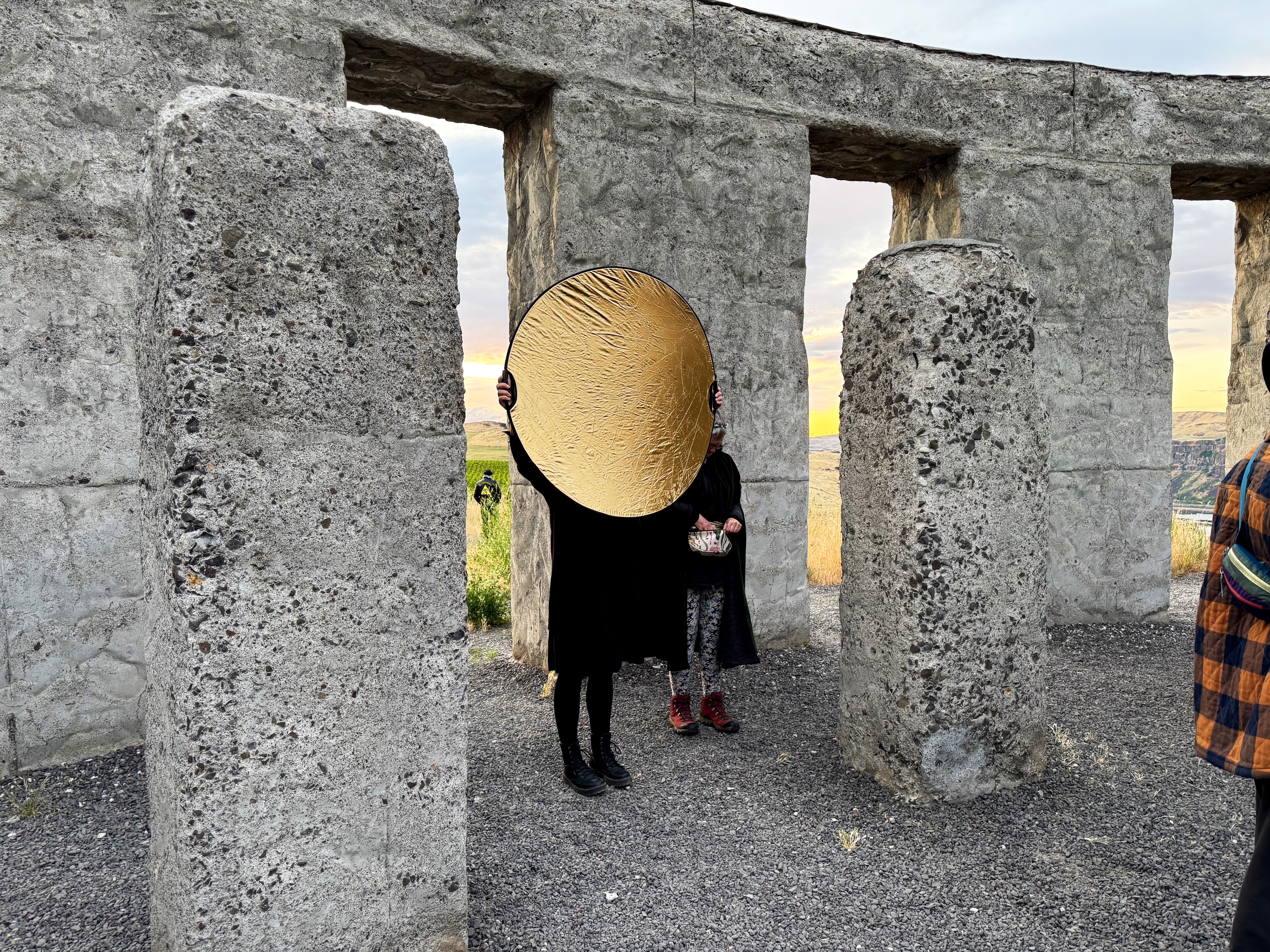 Denise Halackova holds a sun to imitate the sunrise, which was slightly blocked by clouds that were low to the horizon, on June 21, 2025.