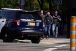 Officers cross the street at the scene of a police shootout at an apartment building on the 1600 block of North Willis Boulevard in North Portland on Aug. 27, 2021.