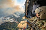 U.S. Army Staff Sgt. Kyle Sanders of the Golf Company, 1st Battalion, 189th Aviation, looks down on the Hagen Fire in Umatilla County, Ore., Aug. 10, 2026, during a water drop. 
