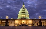 FILE - Lights shine inside the U.S. Capitol Building as night falls on Jan. 21, 2018, in Washington.