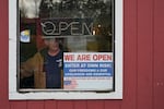 In this Jan. 4, 2021, file photo, a person walks through an entrance to the Farm Boy Drive-In restaurant during a protest rally near Olympia, Wash. The restaurant has been facing fines and penalties for continuing to offer inside dining despite current restrictions on the practice in Washington state due to the coronavirus pandemic.