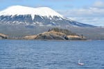 A mini boat sails in front of Mt. Edgecumbe in Alaska's Sitka Sound.