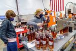 (Left to right) Westward Whiskey employees Lynna Vu and Alyssa McMillen work on the bottling line at the Southeast Portland distillery on Oct. 8, 2021. The company's co-founder Thomas Mooney hailed the end of Europe's 25% tariff on American whiskey, effective Jan. 1, 2022.