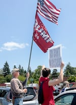 A counter-protester, left, flies a Trump flag at the "No Kings" rally in Newberg, Ore., June 14, 2025. 