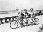 Swimsuit-clad bicycle enthusiasts pedal south from Seaside’s automobile turnaround along the Promenade overlooking sandy beaches and the Pacific Ocean, June 1936. From early days, Oregon’s coastal beaches served as a highway for people on foot and horseback and later carried horse-drawn buggies, stagecoaches and cars.