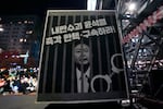 An image of depicting an imprisoned South Korean President Yoon Suk Yeol is displayed during a rally to demand his impeachment, on Friday, Dec. 13, 2024. The signs read "Arrest and impeach the rebellion leader Yoon Suk Yeol."