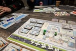 The current PDX board game features different upgrades to players' imaginary airports and also sports some last minute edits made in blue marker.