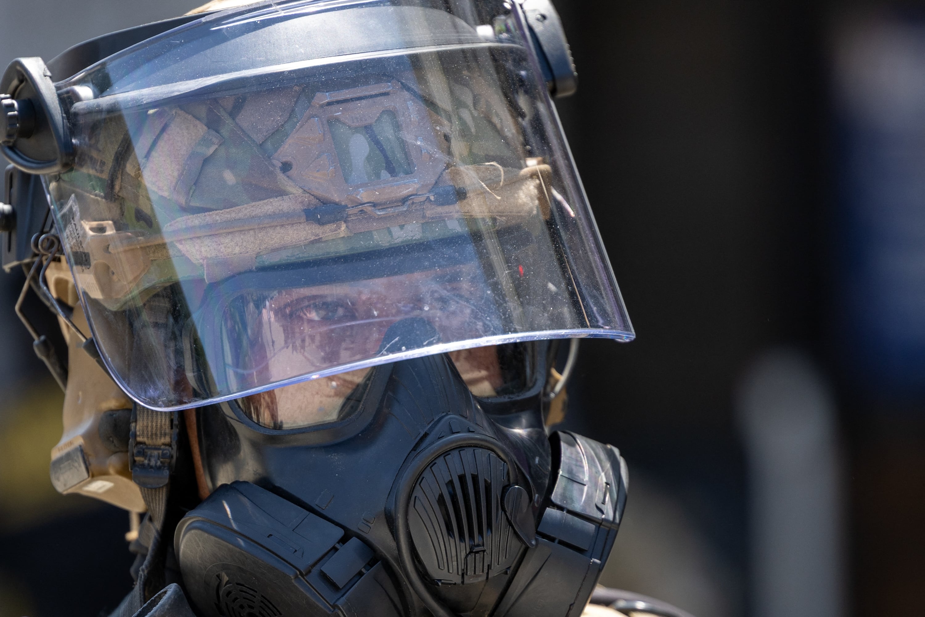 A National Guard officer wearing a helmet with visor and a gas mask stands guard at the Metropolitan Detention Center during an anti-ICE protest in downtown Los Angeles on Sunday.