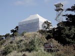 Yaquina Bay Lighthouse remains wrapped in plastic to protect people from the lead paint being scraped off its exterior, on April 30, 2025. The cover should come off by mid-September.