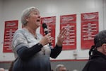 Chris Berrie asks U.S. Sen. Jeff Merkey and Rep. Suzanne Bonamici how Democrats will respond to President Donald Trump's rush of federal cuts and executive orders. She spoke at a town hall at Neah-Kah-Nie High School in Rockaway Beach, Ore., on Feb. 22, 2025.